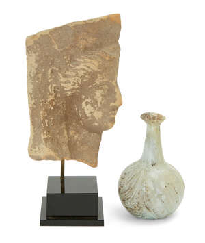 A Greek terracotta fragmentary head of Demeter
		Circa 5th Century B.C.
		From a protome, the hair swept back beneath her polos, 13cm high, and a Roman pale 