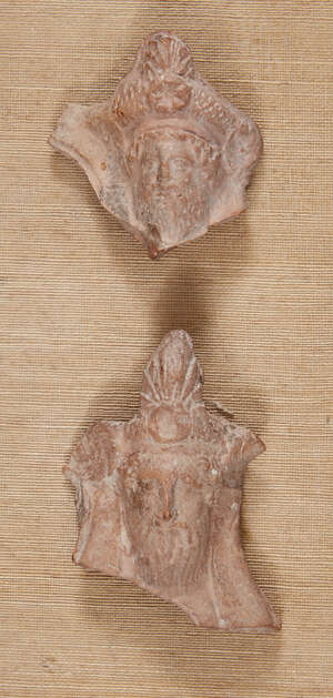Two Greek terracotta hollow-backed relief fragments, each of a bearded male banqueteer wearing tall palmette headdress with frontal rosette, circa 4th Century 