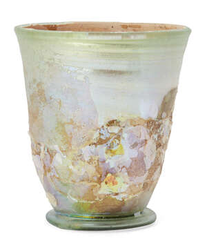 A Roman pale green glass beaker on a folded ring base, with wheel-abraded bands below the rim, circa 4th-5th Century A.D., 8.7cm high