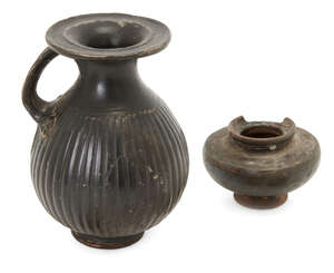 Two black glazed pottery vessels
		Possibly Greek circa 4th Century B.C. 
		One an olpe, the oval body moulded with vertical ribbing, on a low ring base, 12.