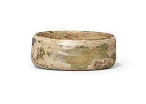 An iridescent glass bowl/lid, Roman or later, 7.2cm diam, 2.8cm high
Provenance: Private UK collection acquired in the 1980s