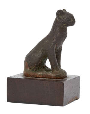 An Egyptian bronze seated cat
		Late Period-Ptolemaic, 664-30 B.C.
		Depicted seated with forepaws together, 5.4cm high, with restorations
		Provenance:
		