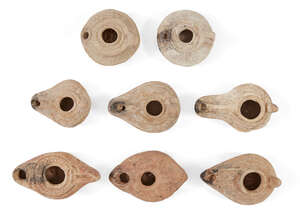 Eight Syrian-Palestinian pottery oil lamps, Circa 5th-7th Century A.D, Six with extended nozzles, sloping shoulders and worn moulded relief, one with a cross o